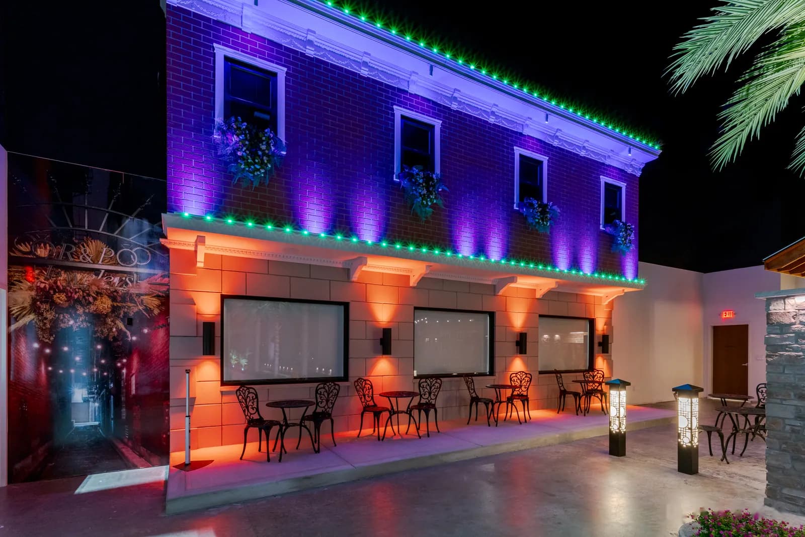 Two-story café façade lit in multicolor for an event
