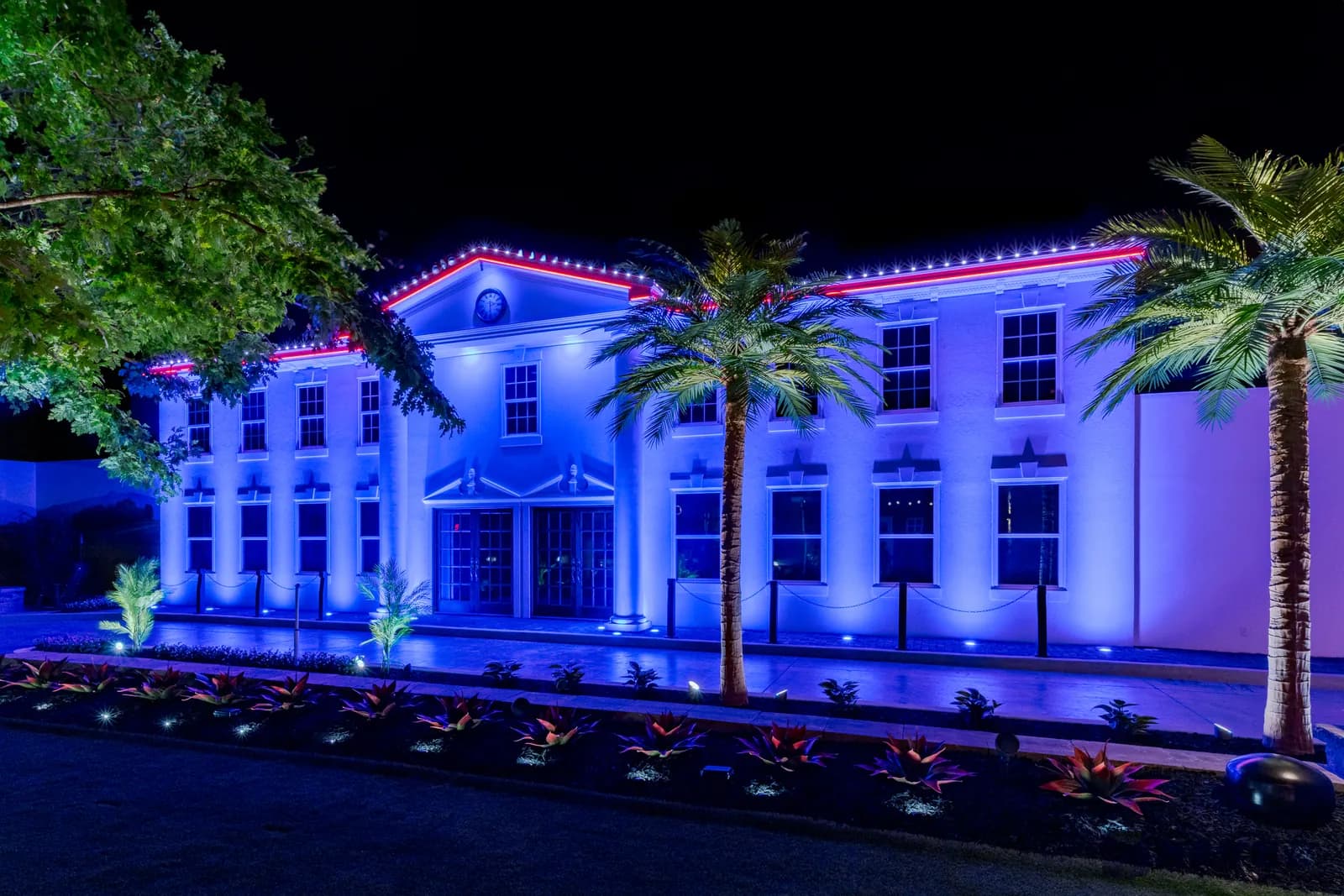 Civic building lit in red, white, and blue for a national holiday