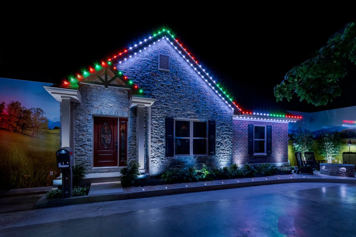 Stone ranch home with red and green Christmas roofline lighting