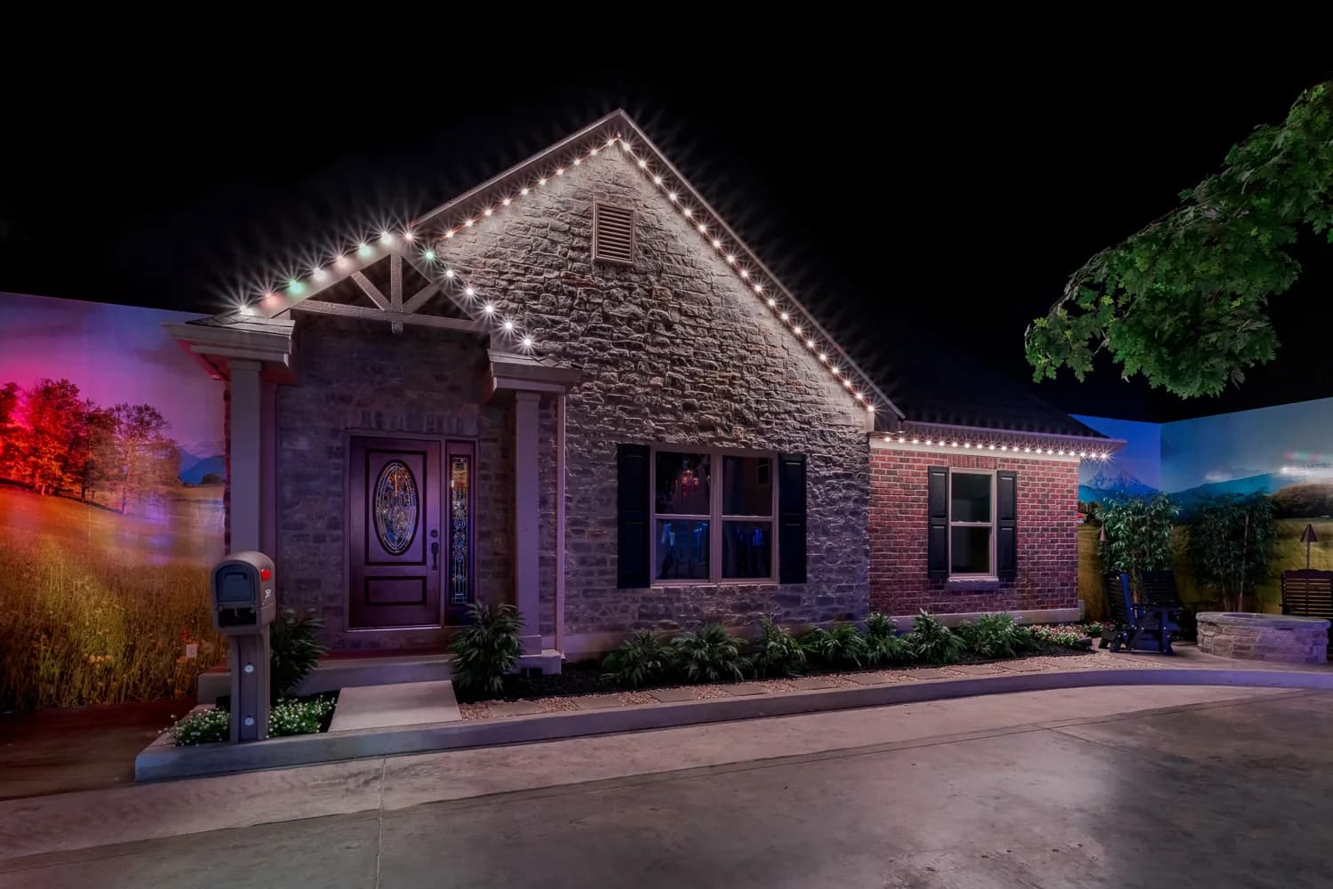 Stone ranch home with permanent warm white roofline lighting at night