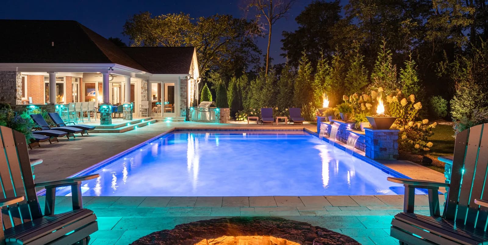 Pool and patio with teal landscape lighting